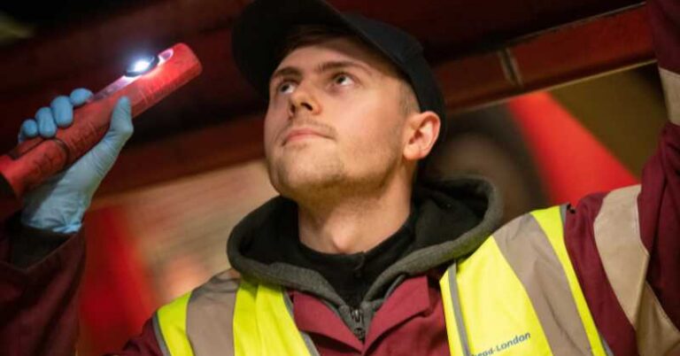 Man looking underneath a bus